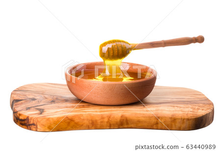 Wooden bowl full of honey and wooden dipper on wooden plank isolated on white Wooden bowl full of honey and wooden dipper on wooden plank isolated on white 63440989
