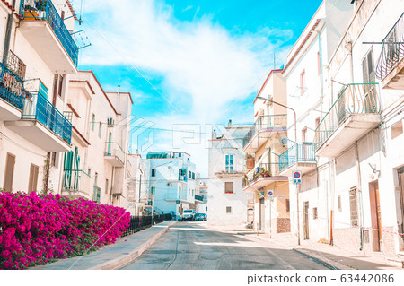 The narrow streets of the island with blue balconies, stairs and flowers. 63442086