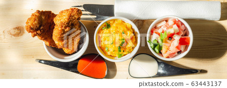 Breaded and herbed chicken breast fillet served 63443137