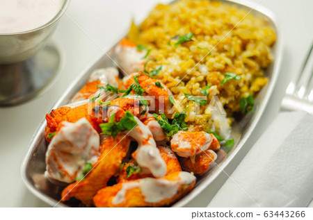 Pieces of cooked marinated chicken breast in an Pieces of cooked marinated chicken breast in an 63443266