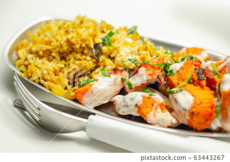 Pieces of cooked marinated chicken breast in an Pieces of cooked marinated chicken breast in an 63443267