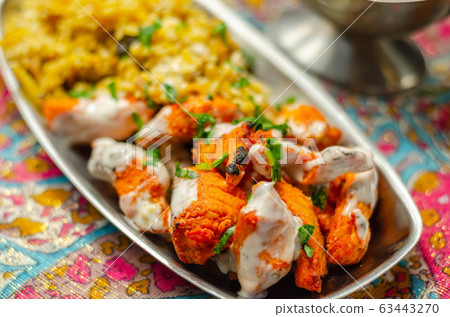 Pieces of cooked marinated chicken breast in an Pieces of cooked marinated chicken breast in an 63443270