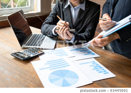 Two business women have analysis the chart, set targets for new management success Two business women have analysis the chart, set targets for new management success 63445691