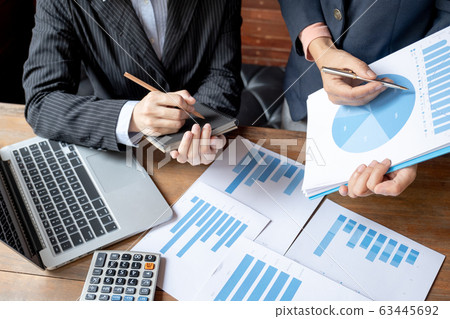 Two business women have analysis the chart, set targets for new management success Two business women have analysis the chart, set targets for new management success 63445692