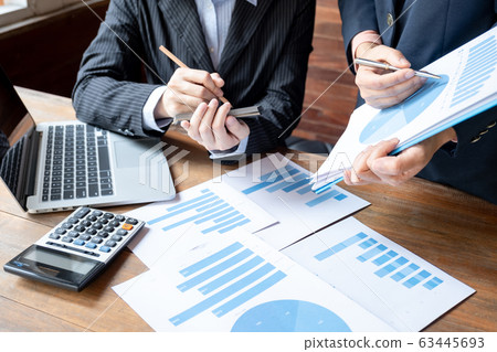 Two business women have analysis the chart, set targets for new management success Two business women have analysis the chart, set targets for new management success 63445693