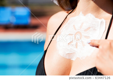 Beautiful woman has a sunscreen in sun shape on Beautiful woman has a sunscreen in sun shape on 63447126