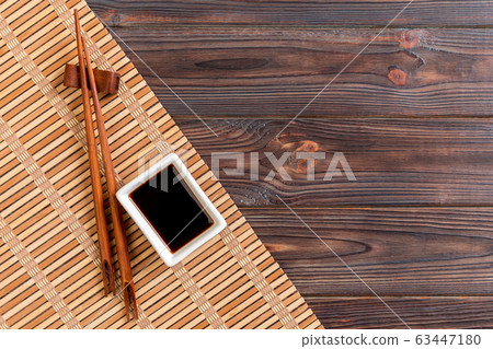 Bamboo mat and soy sauce with sushi chopsticks on Bamboo mat and soy sauce with sushi chopsticks on 63447180