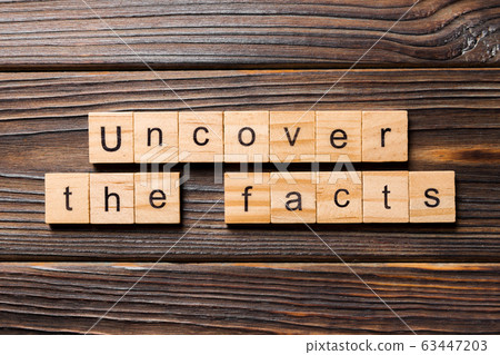 uncover the fact word written on wood block. 63447203