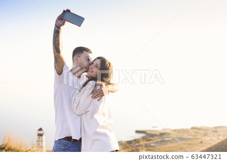 Happy couple taking selfie on beach 63447321