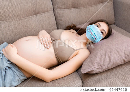 Young pregnant woman in protective medical mask Young pregnant woman in protective medical mask 63447626