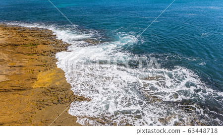 Waves of turquoise water washed by the rocky stone coast of Portugal. Aerial view. 63448718