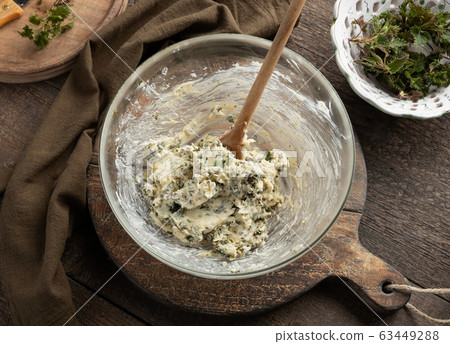 Mixing butter and minced young nettles to prepare herbal butter Mixing butter and minced young nettles to prepare herbal butter 63449288