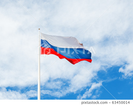 National Russian flag waving on cloudy blue sky background. 63450014