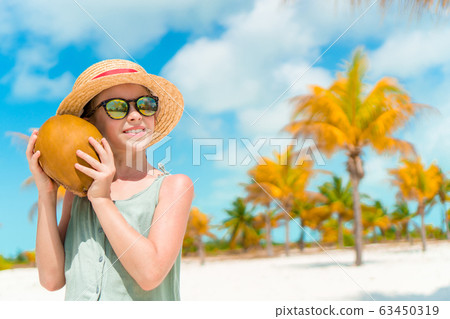 Little adorable girl with big coconut on the beach Little adorable girl with big coconut on the beach 63450319