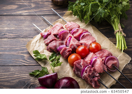 Raw shish kebab skewers with tomatoes 63450547