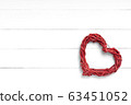 Wicker red heart on white wooden surface. Top view, copy space 63451052