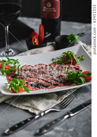 Beef carpaccio on a gray background. Set of carpaccio wine and cutlery, top view. gray background, copy space. Beef carpaccio on a gray background. Set of carpaccio wine and cutlery, top view. gray background, copy space. 63451553