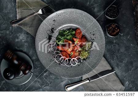 Salad with arugula and fresh pickled tomatoes and onions. Beautiful serving, traditional Italian cuisine, gray background, copy space. food concept 63451597