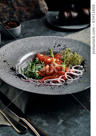 Salad with arugula and fresh pickled tomatoes and onions. Beautiful serving, traditional Italian cuisine, gray background, copy space. food concept Salad with arugula and fresh pickled tomatoes and onions. Beautiful serving, traditional Italian cuisine, gray background, copy space. food concept 63451608