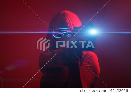 Girl with blaster in the futuristic battle. Concept virtual reality, cyber game. 63452026