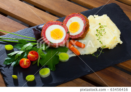 Scotch egg srved with mashed potatoes and greens, Scottish traditional dish Scotch egg srved with mashed potatoes and greens, Scottish traditional dish 63456416