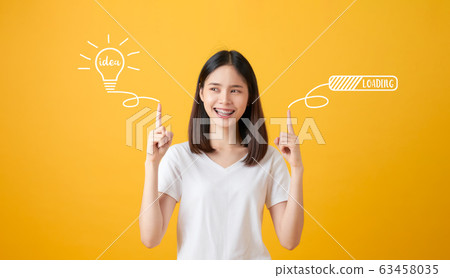 Young smiling Asian woman pointing hands to light bulb with text ideas and loading brainstorm. Young smiling Asian woman pointing hands to light bulb with text ideas and loading brainstorm. 63458035