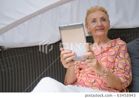 Beautiful senior tourist woman with blond hair relaxing around t 63458943