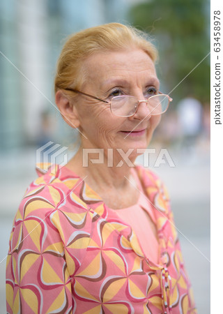 Beautiful senior tourist woman with blond hair relaxing around t 63458978