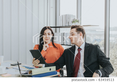 Two business people discussing about work in an Two business people discussing about work in an 63459513