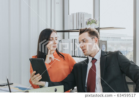 Two business people discussing about work in an 63459517