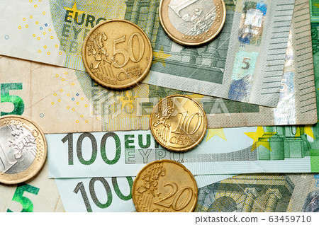 Close-up euro bills and coins lie next to each other 63459710