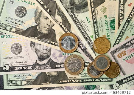 Dollar bills and coins lie next to each other 63459712