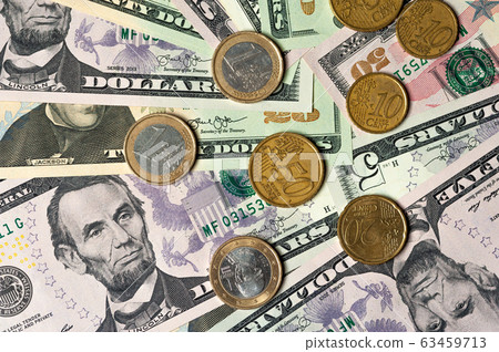 Dollar bills and coins lie next to each other 63459713