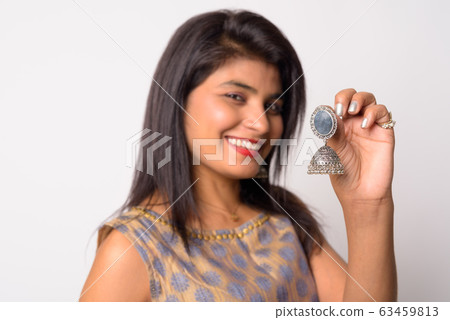 Face of happy young Persian woman holding earring in traditional clothing Face of happy young Persian woman holding earring in traditional clothing 63459813