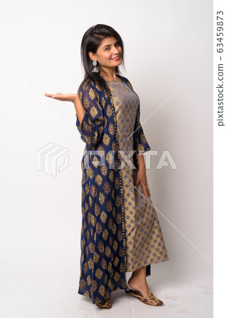 Full body shot of happy young Persian woman showing something in traditional clothing Full body shot of happy young Persian woman showing something in traditional clothing 63459873