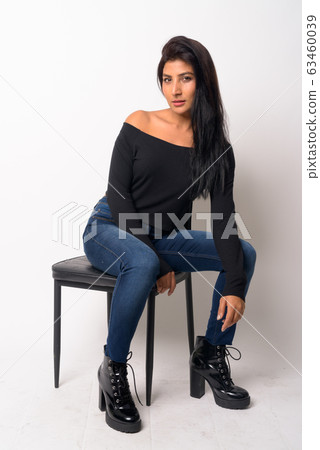 Full body shot of young beautiful Persian woman sitting on the chair 63460039