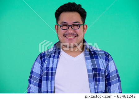 Face of happy young overweight Asian hipster man smiling 63461242