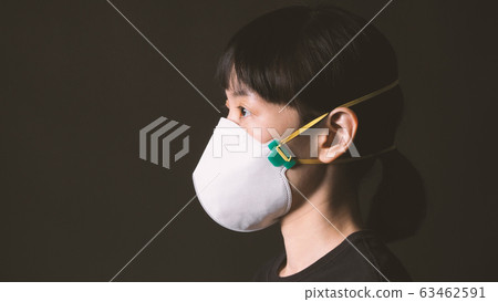 Asian woman wearing n95 healthy mask for protect coronavirus or covid-19 and pm 2.5 dangerous dust from bad air pollution which shoot in studio with clear black color background. 63462591