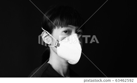 Asian woman wearing n95 healthy mask for protect coronavirus or covid-19 and pm 2.5 dangerous dust from bad air pollution which shoot in studio with clear black color background. 63462592