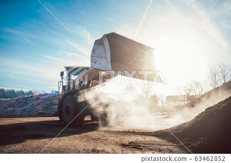 Bulldozer putting biomass on pile for composting 63462852