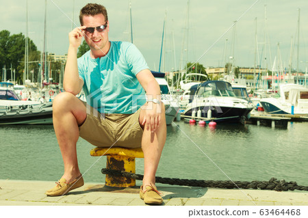 Man walking on marina during summer Man walking on marina during summer 63464468