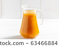 Glass jar of sea-buckthorn drink on wooden table 63466884
