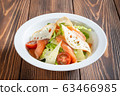 White plate of caesar salad with smoked salmon  63466985