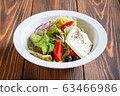 Plate of fresh greek salad on wooden table 63466986