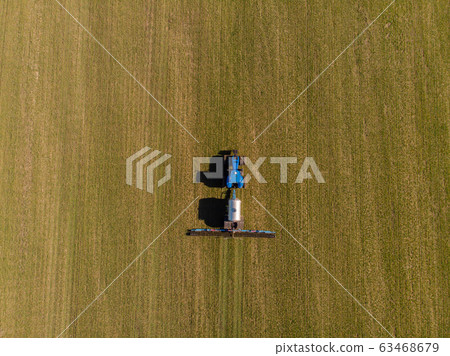 Tractor applying liquid mineral fertilizers to the soil on winter wheat Tractor applying liquid mineral fertilizers to the soil on winter wheat 63468679
