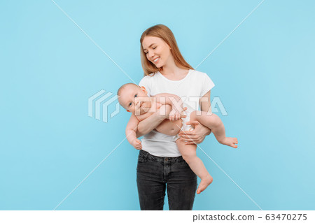 Happy cheerful mom playing with her little baby on Happy cheerful mom playing with her little baby on 63470275