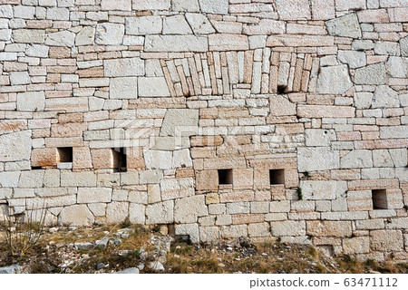 Austrian fortified wall made of stone blocks with arrowslits 63471112