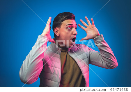 Caucasian man's portrait isolated on blue studio background in neon light 63471488