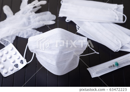 Medical white masks on a black background. Surgical protective mask against viruses and bacteria. The concept of protection against influenza, coronavirus, tonsillitis. Medical white masks on a black background. Surgical protective mask against viruses and bacteria. The concept of protection against influenza, coronavirus, tonsillitis. 63472223