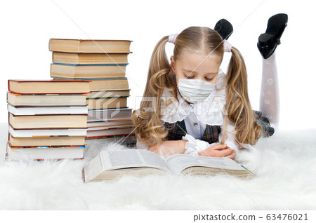 little teen girl in medical mask lie home and read 63476021